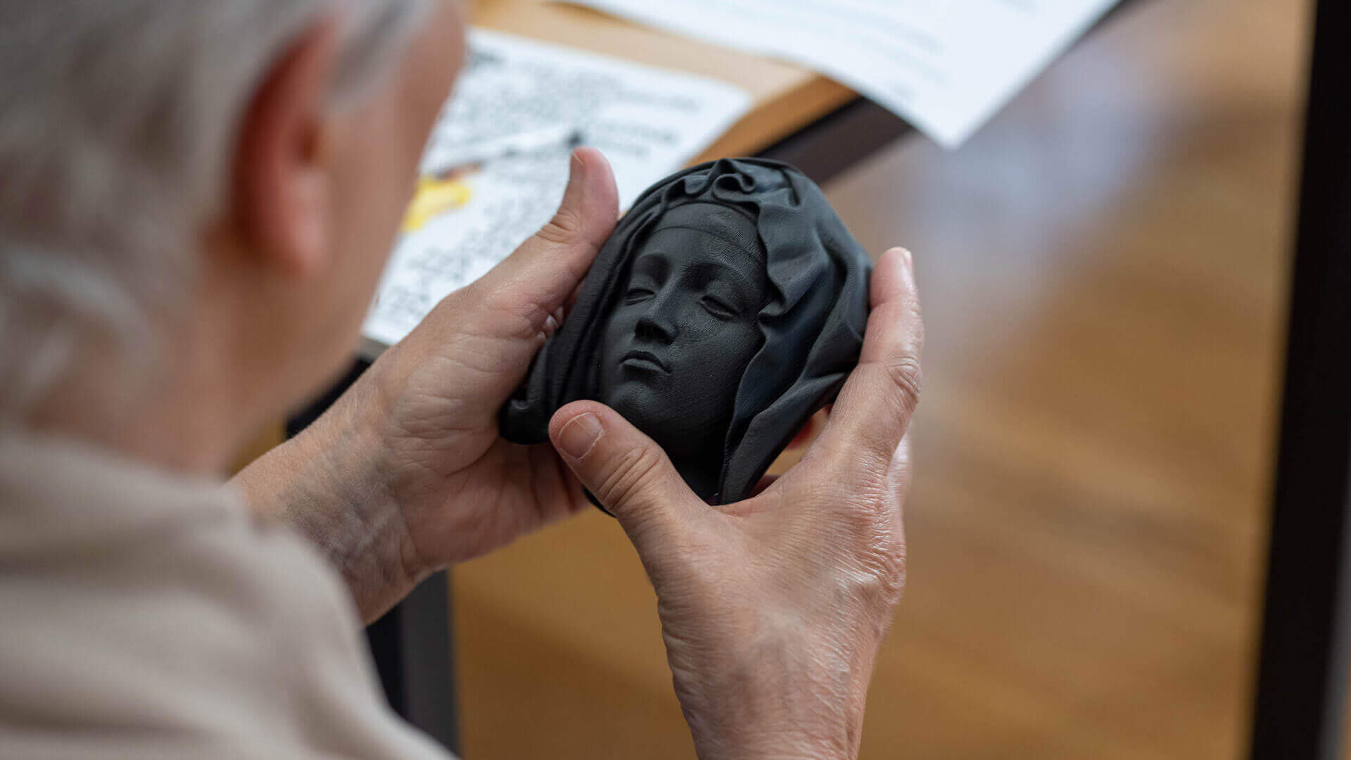 senior citizen exploring a head of a art piece in museum of são roque